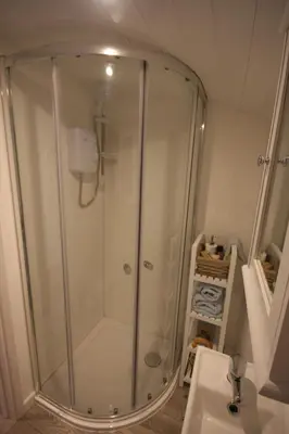 a shower stall in a bathroom with a sink at Shepherds Hut 7 in Bedfield