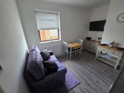 a living room with a couch and a table at Promenade Apartment in Maldon