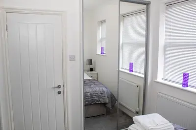 a room with a mirror and a bedroom with a bed at Promenade Apartment in Maldon