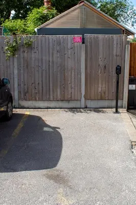 a parking meter in front of a wooden fence at Promenade Apartment in Maldon