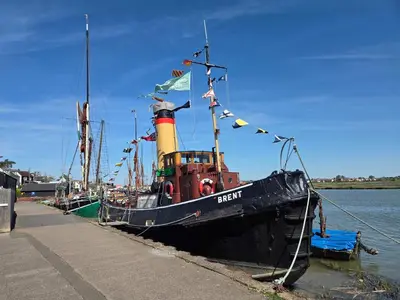 a boat docked at a dock with flags on it at Promenade Apartment in Maldon