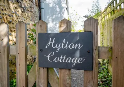 a sign on a wooden fence with a religion cartridge at Hylton Cottage, Lavenham in Lavenham