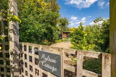a wooden fence with a sign that reads autism exchange at Hylton Cottage, Lavenham in Lavenham