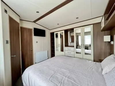 a bedroom with a large white bed in it at VerbLake 5 Berth Caravan St Osyth Beach Holiday Park in Saint Osyth