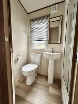 a small bathroom with a toilet and a sink at VerbLake 5 Berth Caravan St Osyth Beach Holiday Park in Saint Osyth