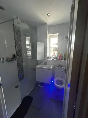 a bathroom with a toilet and a sink with blue lights at Rooms in Granary House, Newmarket in Newmarket