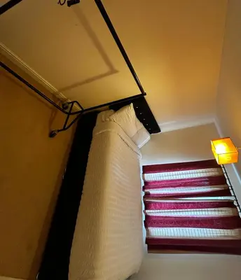 a bedroom with a window with a curtain and a lamp at Rooms in Granary House, Newmarket in Newmarket