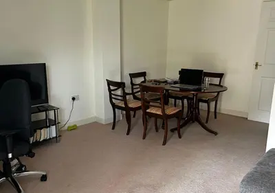 a dining room with a table with a laptop on it at Rooms in Granary House, Newmarket in Newmarket
