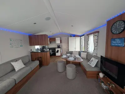 a living room with a couch and a table at LuKa25 GC080 in Saint Osyth