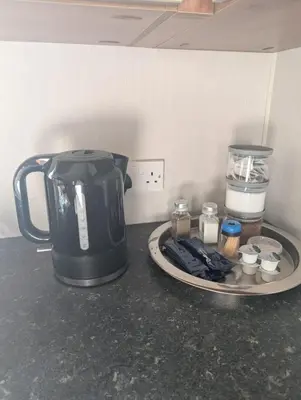 a black tea kettle and a plate on a counter at LuKa25 GC080 in Saint Osyth