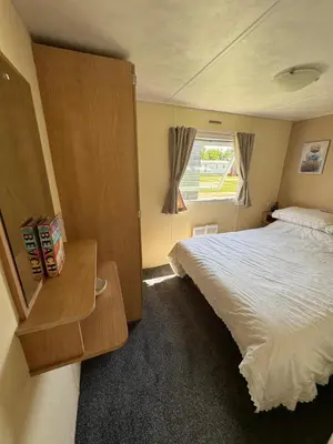 a small bedroom with a bed and a window at Cabana Escape in Little Clacton