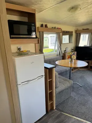 a kitchen and living room of an rv with a refrigerator at Cabana Escape in Little Clacton