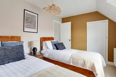 a bedroom with two beds and a ceiling fan at Cosy 3 bedroom house with Free parking and WiFi in Colchester