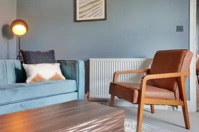 a living room with a blue couch and a chair at Cosy 3 bedroom house with Free parking and WiFi in Colchester