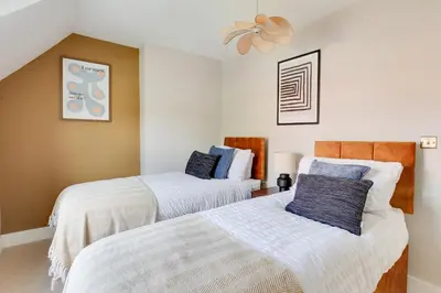 a bedroom with two beds and a ceiling fan at Cosy 3 bedroom house with Free parking and WiFi in Colchester