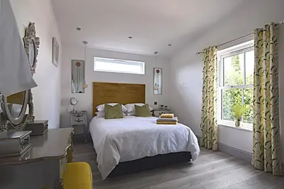 a bedroom with a large bed and a window at Beautiful Lodge in Newmarket with parking in Newmarket