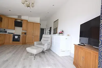 a living room with a chair and a television at Beautiful Lodge in Newmarket with parking in Newmarket