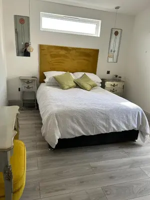 a bedroom with a large bed and a window at Beautiful Lodge in Newmarket with parking in Newmarket