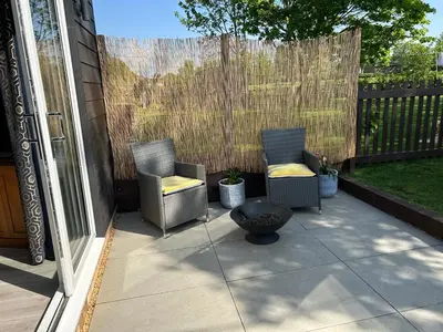 a patio with two chairs and a fire hydrant at Beautiful Lodge in Newmarket with parking in Newmarket