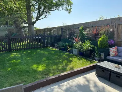 a garden with a fence and a couch and some plants at Beautiful Lodge in Newmarket with parking in Newmarket