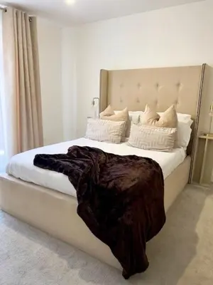a bedroom with a large bed with a blanket on it at TT Maison in Brentwood