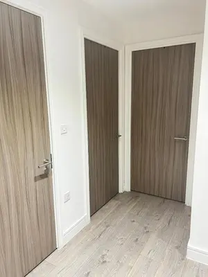 two doors in an empty room with wooden floors at TT Maison in Brentwood