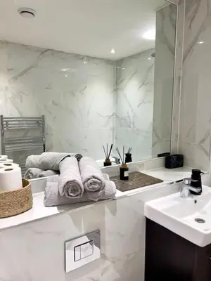 a bathroom with a sink and a mirror and towels at TT Maison in Brentwood