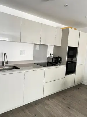 a white kitchen with a sink and a microwave at TT Maison in Brentwood