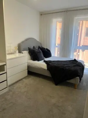 a bedroom with a bed with black sheets and a window at TT Maison in Brentwood