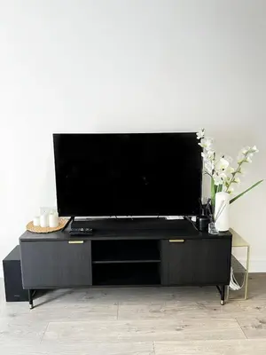 a large black entertainment center with a flat screen tv at TT Maison in Brentwood