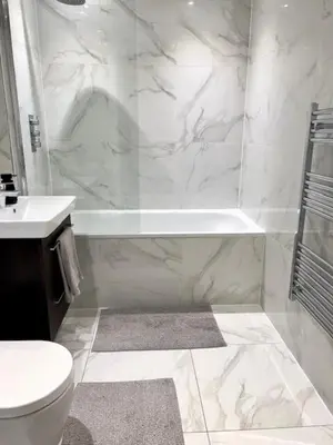 a white bathroom with a tub and a toilet and a sink at TT Maison in Brentwood