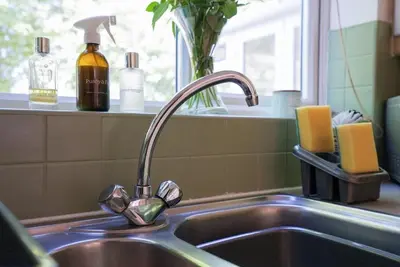 a kitchen sink with a faucet next to a window at Spacious 5 Bedrooms Sleeps 9 3 Bath and Parking Ideal for Contractors in Chesfield