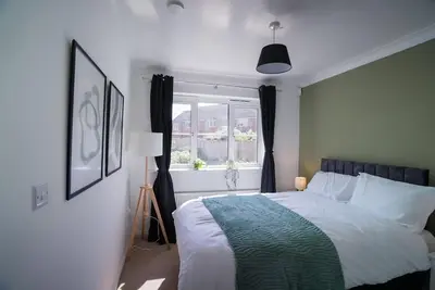 a bedroom with a large bed and a window at Spacious 5 Bedrooms Sleeps 9 3 Bath and Parking Ideal for Contractors in Chesfield