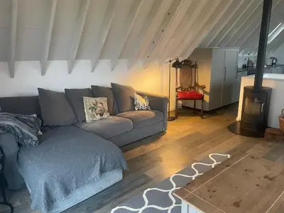 a living room with a couch and a fireplace at Well Barn in Sudbourne