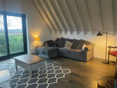 a living room with a couch and a coffee table at Well Barn in Sudbourne