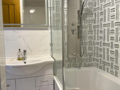 a white bathroom with a sink and a shower at Lighthouse Lodge in Harwich