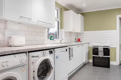 a white kitchen with a washer and dryer at Modern bedrooms-Family -Free Parking-Hi-Speed WiFi-Sleeps 5 in Colchester