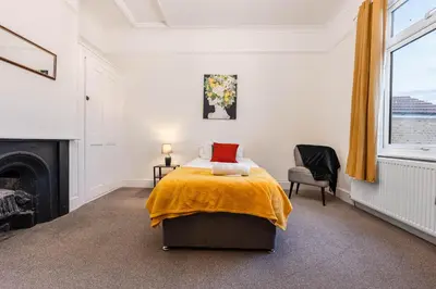 a bedroom with a bed with a yellow blanket on it at Modern bedrooms-Family -Free Parking-Hi-Speed WiFi-Sleeps 5 in Colchester