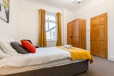a bedroom with a bed with red and yellow pillows at Modern bedrooms-Family -Free Parking-Hi-Speed WiFi-Sleeps 5 in Colchester