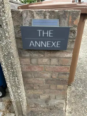 a sign that says the answer on a brick wall at The Annexe Long Melford in Long Melford