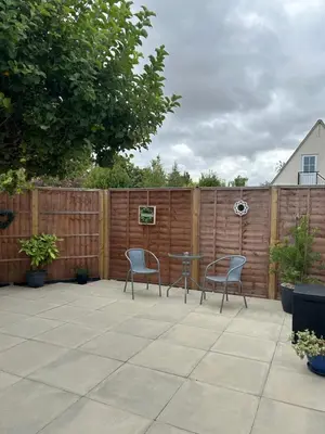 a patio with two chairs and a table and a fence at The Annexe Long Melford in Long Melford