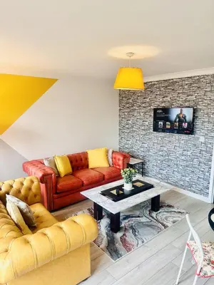 a living room with a couch and a table at Pleasant and Homely in Colchester
