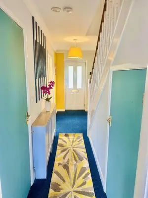 a hallway with a blue and yellow hallway with a door at Pleasant and Homely in Colchester