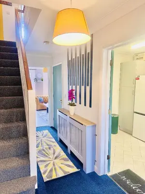 a hallway of a home with stairs and a yellow ceiling at Pleasant and Homely in Colchester
