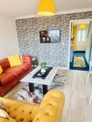 a living room with a couch and a table at Pleasant and Homely in Colchester