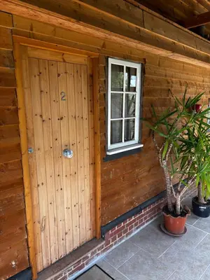 a wooden cabin with a door and a window at Thaxted Bed & Breakfast and Accommodation in Thaxted