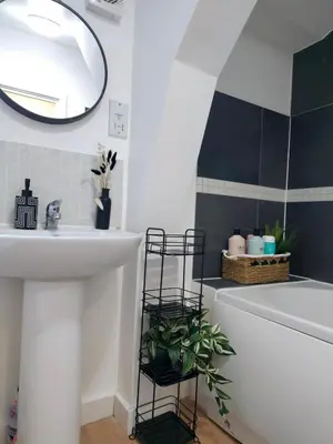 a bathroom with a sink and a tub and a mirror at Canalside 1 bed flat in Hertford