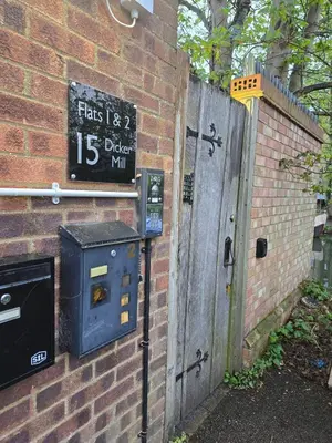 a brick wall with a pay meter next to a door at Canalside 1 bed flat in Hertford