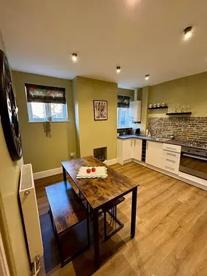 a kitchen with a wooden table in a room at Quaint Bury St Edmunds Cottage in Bury Saint Edmunds