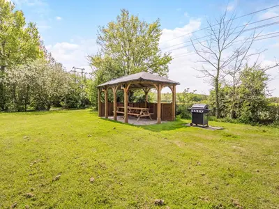 a gazebo in a field with a trash can at Chestnut Tree Barn in Saint Lawrence